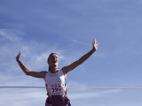 Female Runner Victorious at the Finish Line in a Track Race Photographic Print