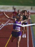 Female Runner Victorious at the Finish Line in a Track Race Photographic Print