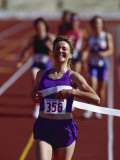 Female Runner Victorious at the Finish Line in a Track Race Photographic Print