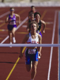 Female Runner Victorious at the Finish Line in a Track Race Photographic Print