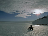 Explorer Drives an Atv across a Shimmering Bare Ice Glacier Photographie par Gordon Wiltsie