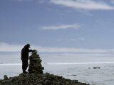 Inuit Hunter Surveys a Sacred Inuksuk Monument, Used as a Waypost Photographie par Gordon Wiltsie