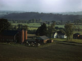 Day Breaks over a Dairy Farm Where Cows Rest in a Pen Near a Barn Photographic Print by B. Anthony Stewart