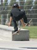 Young Boy Flying Through the Air on a Skateboard, from Behind Photographie par Stephen Sharnoff