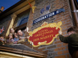 Children Lean Out Window to Hang Sign for their Newly Crowned Queen Photographie par David Boyer