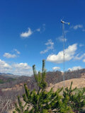 Residential Wind Turbine Towers Above a Ridge in the Mountains Photographic Print by White & Petteway 