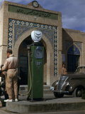 Man Buys Gas from Pump with Company Name in Arabic and English Script Photographic Print by Maynard Owen Williams