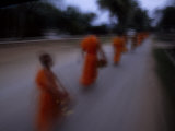 Buddhist Monks Walking to the Temple in the Early Morning Photographie par Paul Chesley