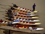 Laotian Man with Long-Tail Boats at a Dock Photographie par Paul Chesley