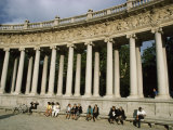 Women Relax on Benches under Columns at a Plaza Outdoors Photographie par Paul Chesley