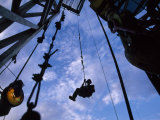Worker Returns to Earth after Lubricating the Top of a Drilling Rig Photographie par Joel Sartore