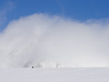 Two Distant Climbers Ascend a Glacier Toward a Cloud-Covered Peak Photographic Print by John Dunn