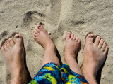 Man's and Small Boy's Feet in Beach Sand Photographic Print by Mattias Klum