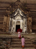 Young Burmese Girls Emerge from a Temple Carved in Rock Photographie par Paul Chesley
