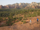 Two Men on Unicycles Ride a Rocky Ridge in the Arizona Desert Photographie par Skip Brown