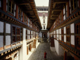 Monk Walks Through the Fortress-Style Architecture of a Dzong Photographie par Paul Chesley
