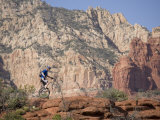 Man on a Unicycle Rides Along a Rocky Ridge in the Arizona Desert Photographie par Skip Brown