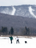 Couple and their Dog Cross Country Skiing on a Frozen Lake Photographie par Skip Brown