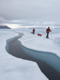 Two Skiers Pull their Sleds on the Sea Ice Next to an Open Lead Photographic Print by John Dunn