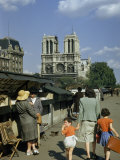 Mother Hurries Children Past Book Stalls Near Notre Dame De Paris Lámina fotográfica por Justin Locke