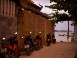 Motorcycles Along a Wall at the Waterfront at Sunset on Koh Lanta Photographic Print by Rebecca Hale