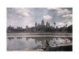 Person Sits by a Moat Which Surrounds the Towers of Angkor Vat Photographie par Gervais Courtellemont