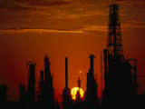 Oil Refinery Silhouetted During a Dramatic Sunset Photographie par Paul Chesley
