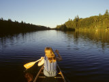 Woman Paddles a Canoe on a River in the Adirondacks Photographie par Skip Brown