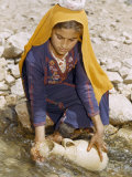 Woman Collects Water in an Old-Fashioned Pottery Jug Photographie par David Boyer