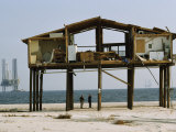 Men Look at a Hurricane Destroyed Home on a Beach. Oil Rigs Offshore Fotografisk tryk af Paul Chesley Men Look at a Hurricane Destroyed Home on a Beach. Oil Rigs Offshore Fotografisk tryk af Paul Chesley