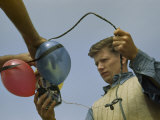 Man Holds Electrical Leads to Equipment Tied to Flotation Balloons Photographic Print by Robert Sisson