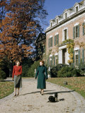 Women Walk Belgian Schipperkes on a Path Beside an Urban Mansion Photographic Print by Howell Walker