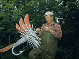 Fishing Tackle Dealer Holds Giant Fly, an Advertisement for His Shop Fotografisk trykk av Andrew Brown Fishing Tackle Dealer Holds Giant Fly, an Advertisement for His Shop Fotografisk trykk av Andrew Brown