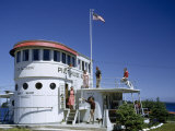People Stand Outside Resort Office Built from a Ship's Superstructure Fotografisk trykk av Andrew Brown People Stand Outside Resort Office Built from a Ship's Superstructure Fotografisk trykk av Andrew Brown
