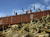 Men Unload Logs from a Railroad Car at a Paper Company Photographie par Robert Sisson