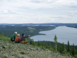 Men Survey Wilderness Terrain from a Hill Overlooking a Lake Fotografisk trykk av Andrew Brown Men Survey Wilderness Terrain from a Hill Overlooking a Lake Fotografisk trykk av Andrew Brown