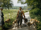 Woman Talks with a Man Walking Racing Greyhounds Photographie par B. Anthony Stewart