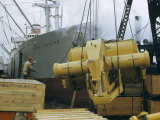 Longshoreman Directs Loading of Road-Building Machine onto Cargo Ship Lámina fotográfica por Justin Locke