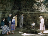 Tourists Peer into Sinking Spring in a Limestone Recess Photographie par Willard Culver