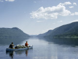 Men Paddle a Canoe Loaded with Gear across a Tranquil Lake Fotografisk trykk av Andrew Brown Men Paddle a Canoe Loaded with Gear across a Tranquil Lake Fotografisk trykk av Andrew Brown