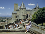 Woman Sitting on Stone Wall Watches People Touring Castle's Ramparts Photographie par Walter Meayers Edwards