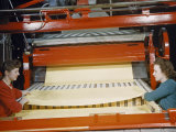Women Pull Large Sheets of Finished Paper from a Cutting Machine Photographie par Robert Sisson