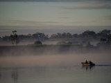 Local Fishermen Paddle a Rowboat Through the Early Morning Mist on the Clarence River Photographic Print by Medford Taylor