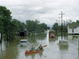 Men Paddle Canoe Down Street Submerged by Flash Flood in May 1951 Photographie par Jack Fletcher