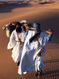 Berber Tribesmen Lead their Camels Through the Sand Dunes of the Erg Chegaga, in the Sahara Region  Photographie par Mark Hannaford