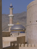 Blue and Gold Dome and Minaret of Masjid Sultan Qaboos are Framed by the Towers of Nizwa Fort Photographic Print by John Warburton-lee