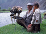 Mongolia, Kasakh Hunter with Eagle by the Khovd River, with a Small Child Fotografie-Druck von Antonia Tozer