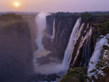 Sunset over Magnificent Victoria Falls, One of Natural Wonders of World Fotografisk tryk af Nigel Pavitt Sunset over Magnificent Victoria Falls, One of Natural Wonders of World Fotografisk tryk af Nigel Pavitt