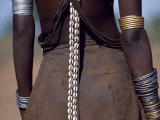 Young Dassanech Girl Wears a Leather Skirt, Metal Bracelets and Amulets and Layers of Bead Necklace Photographic Print by John Warburton-lee