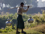 Burma, Mrauk U, A Rakhine Man Carries Water in Aluminium Pots Near Mrauk U, Myanmar Photographic Print by Nigel Pavitt